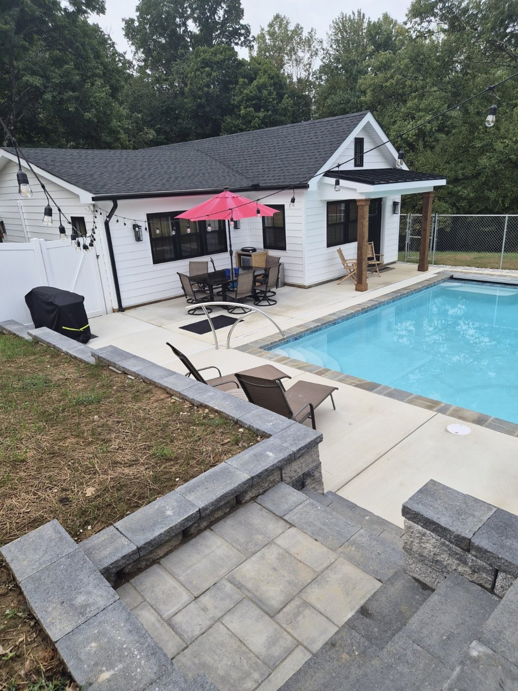 Backyard pool with patio and retaining wall