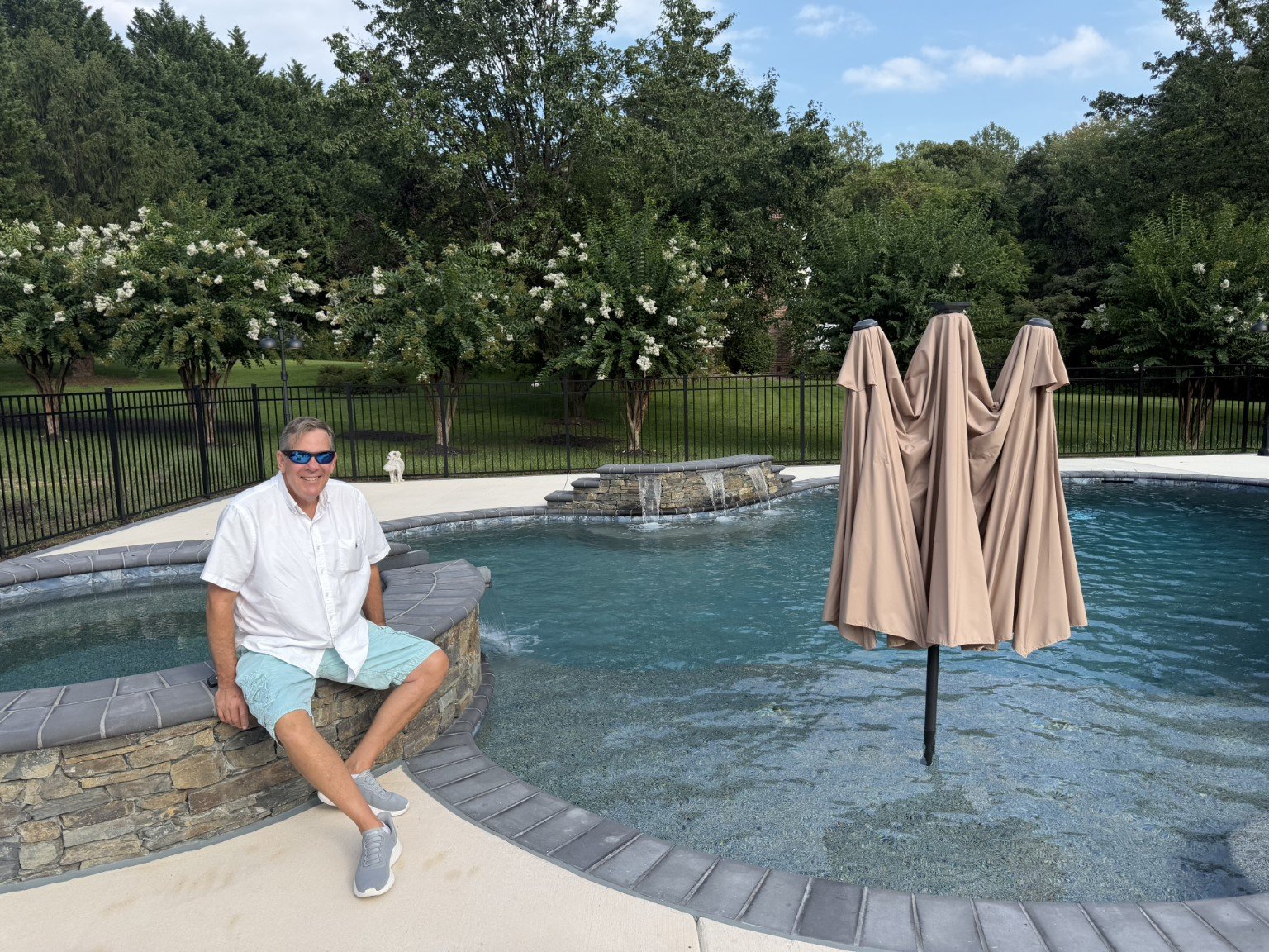 Pool designer beside a custom freeform pool