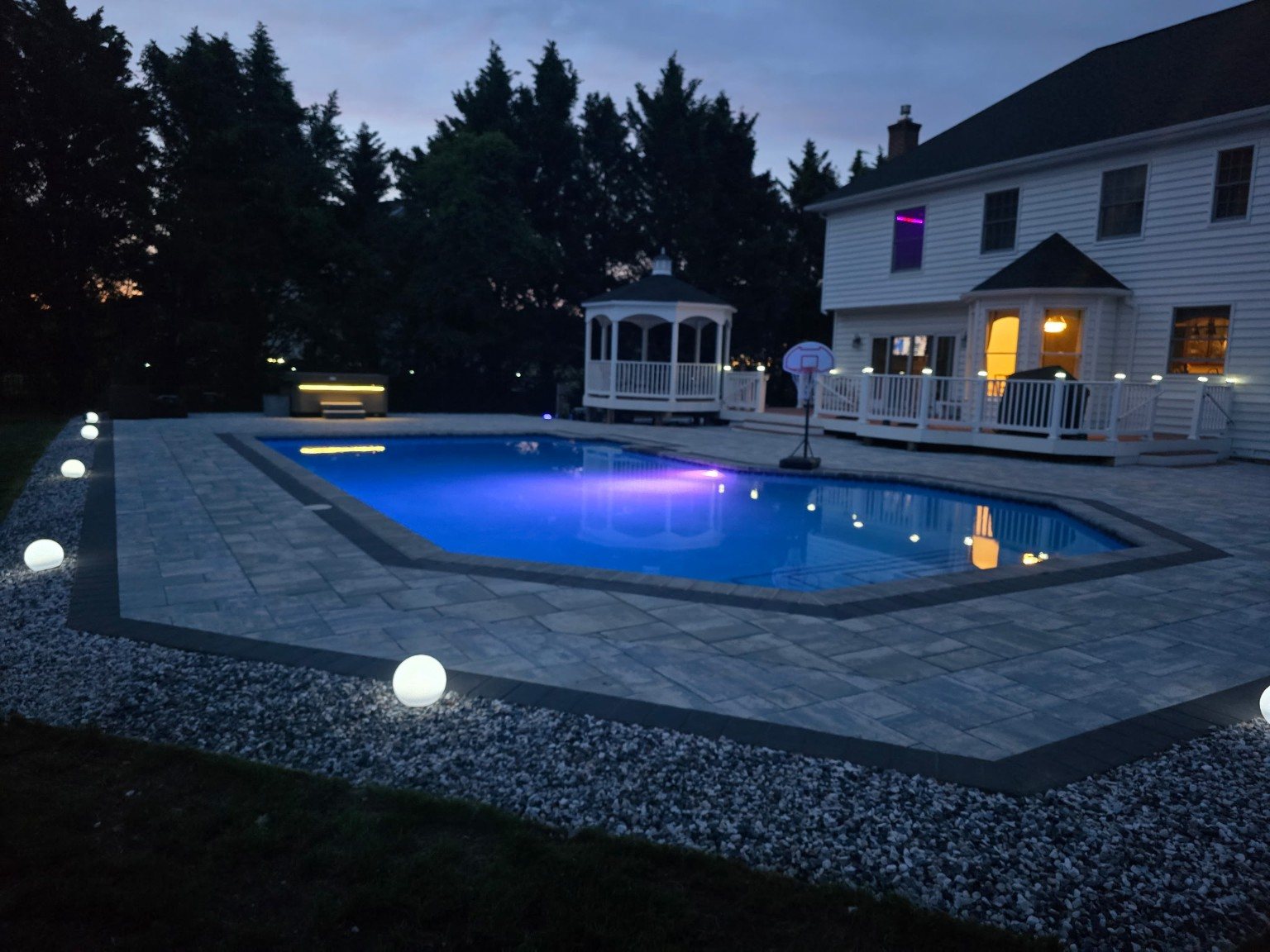 Evening pool lighting and expansive paver patio